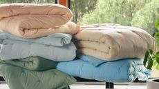 New Brooklinen Percale Comforters in every colorway styled in a sunlit room with large windows overlooking a nature scene.