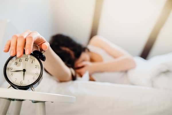 woman waking up to alarm clock